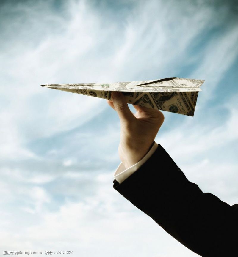 金融货币手拿美元折成纸飞机