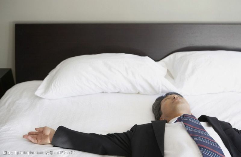 职业男性躺在床上的商务人士图片