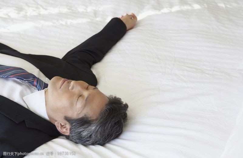 职业男性躺在床上休息的白领图片